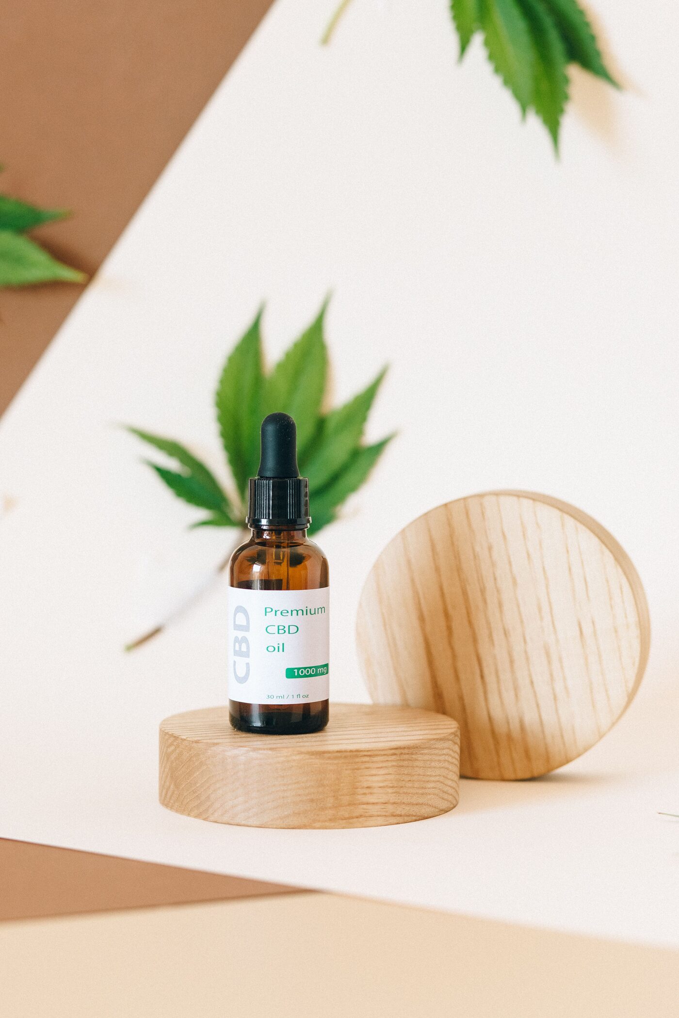 Frasco de óleo de CBD com folha de cannabis ao fundo